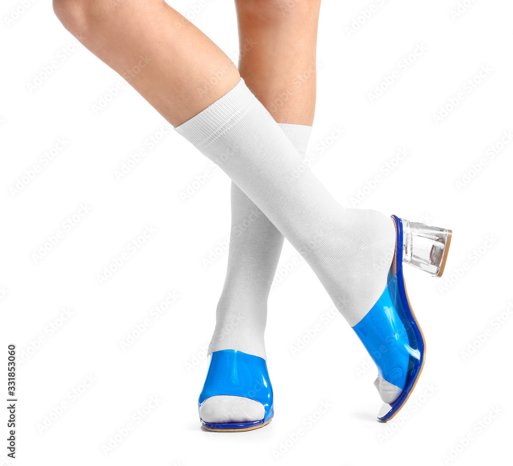 Legs of young woman in socks and shoes on white background