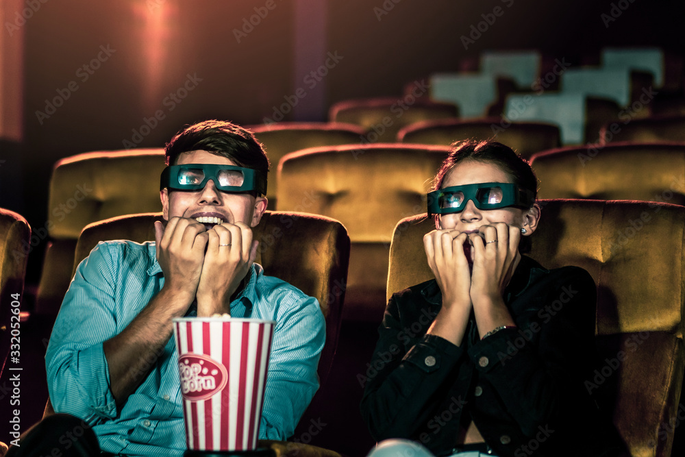 Man and woman in the cinema watching a 3D movie