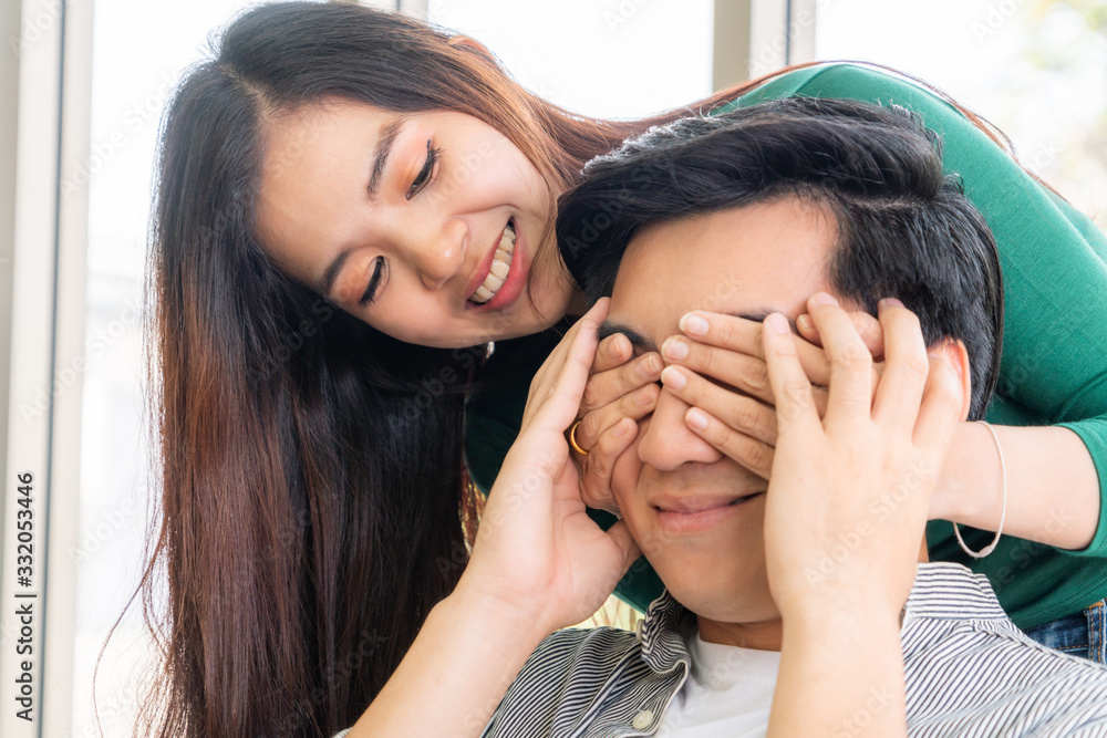 Happy Asian couple play covering eyes.