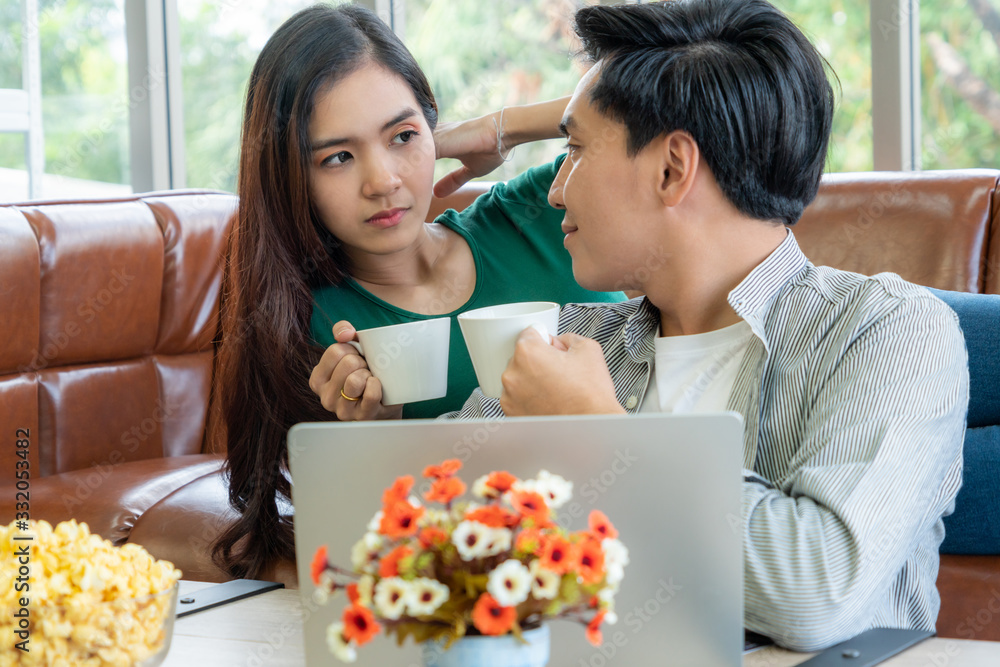 幸福的亚洲夫妇在家喝咖啡。