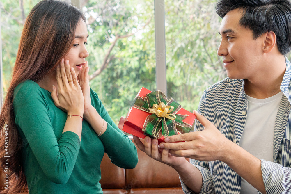 Happy couple giving gift present to celebrate