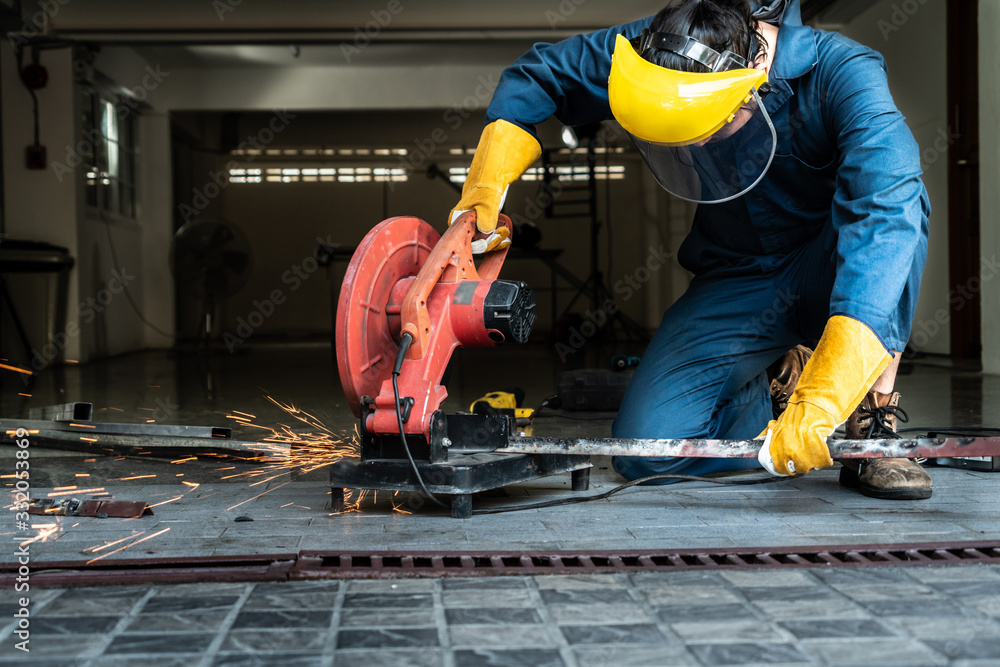 Professional mechanic is cutting steel metal.