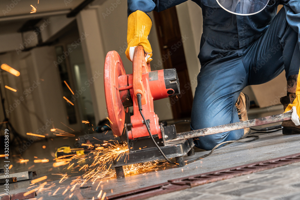 Professional mechanic is cutting steel metal.