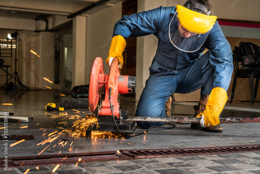 Professional mechanic is cutting steel metal.