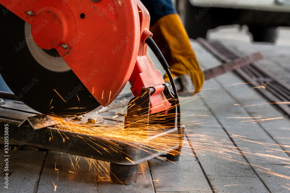 Professional mechanic is cutting steel metal.