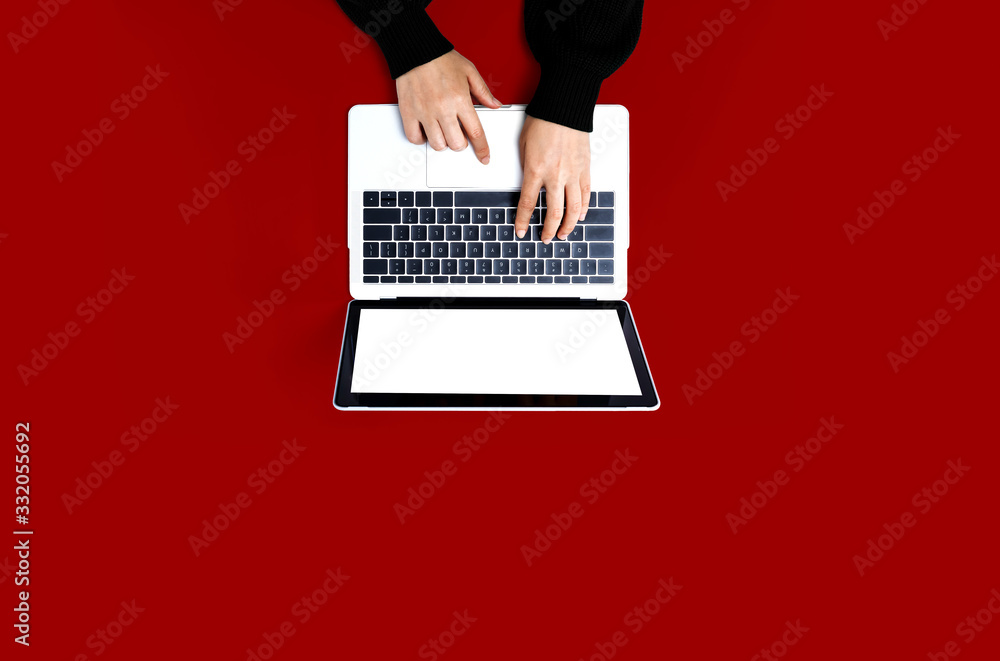 Person using a laptop computer on a solid color background