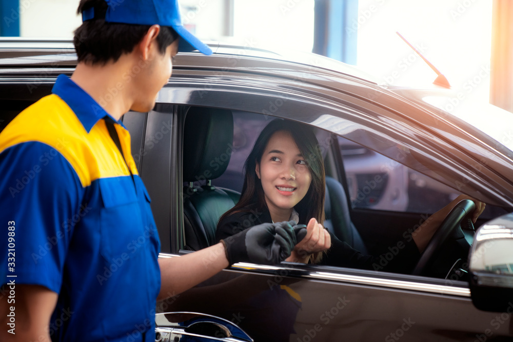 Asian lady got a key from technician after checked her car in car  service center