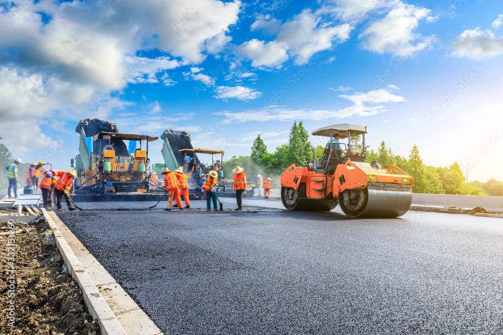 Construction site is laying new asphalt road pavement,road construction workers and road constructio