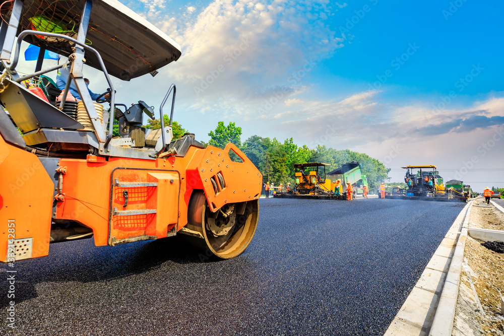 Construction site is laying new asphalt road pavement,road construction workers and road constructio