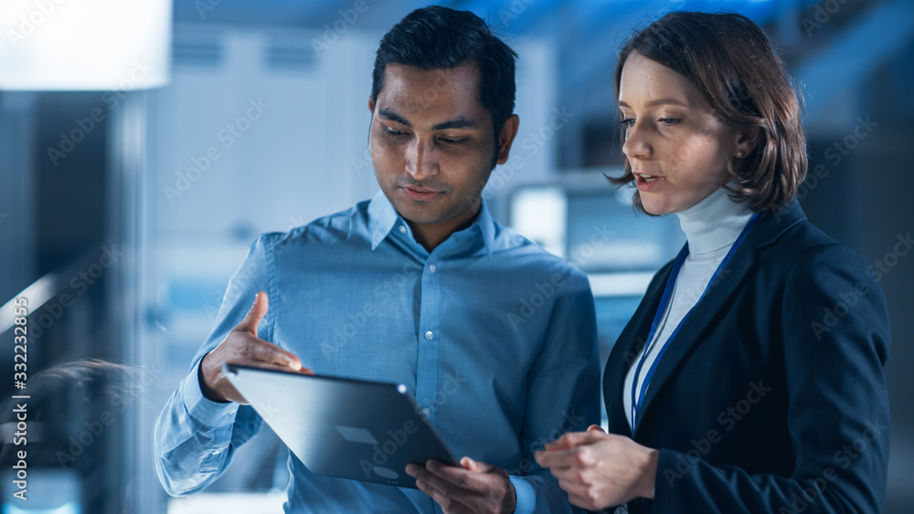 In Technology Research Facility: Female Project Manager Talks With Chief Engineer, they Consult Tabl