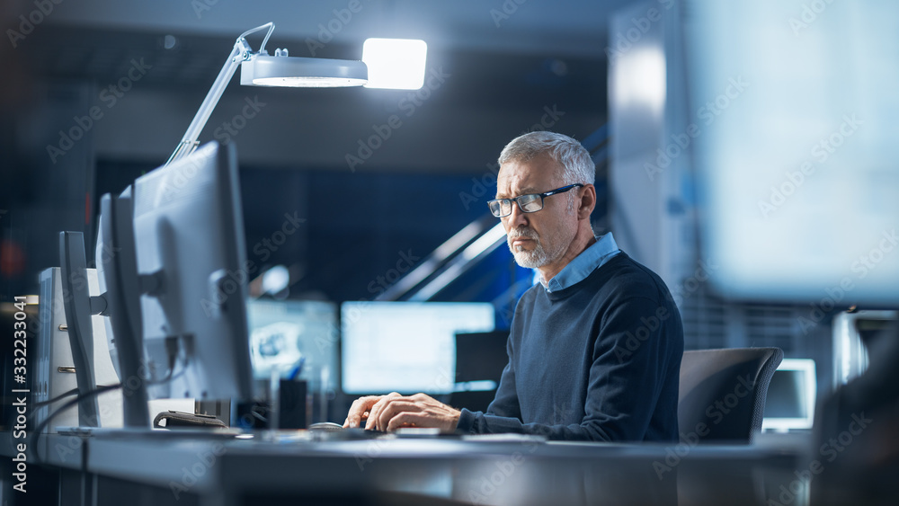 Shot of Industrial Engineer Working in Research Laboratory / Development Center, Using Computer. He 