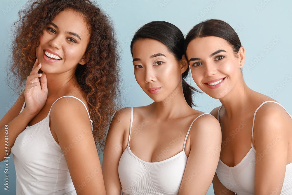 Beautiful young women with healthy skin on color background