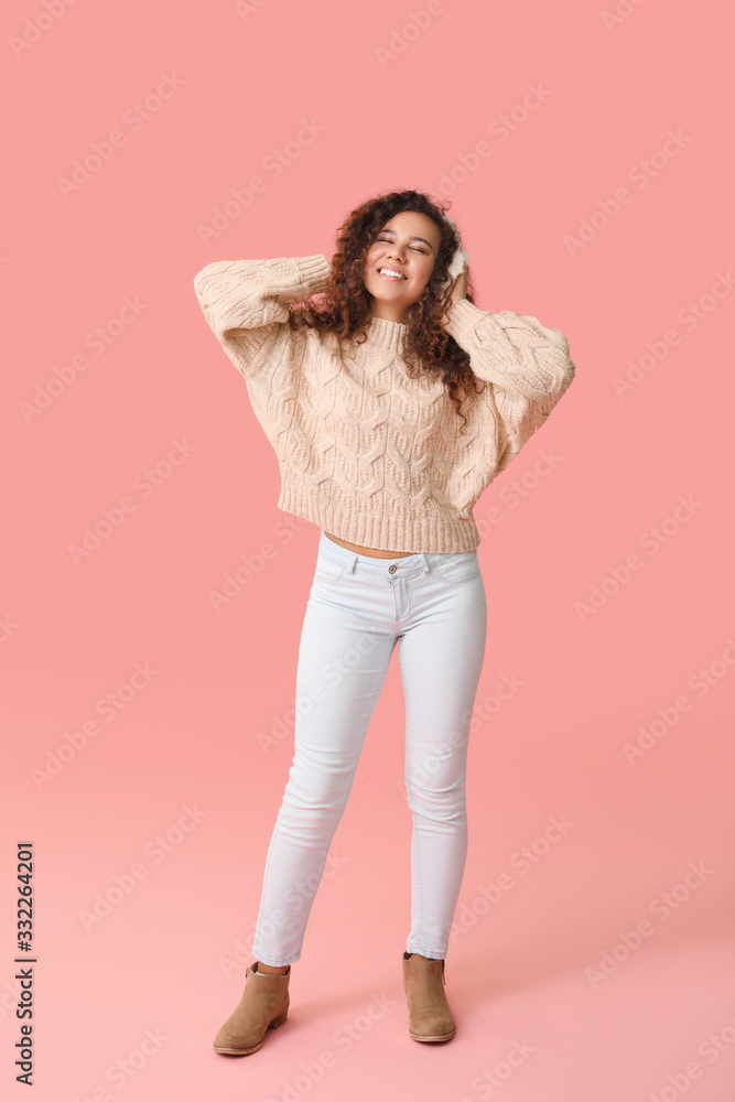 Young woman in warm sweater on color background