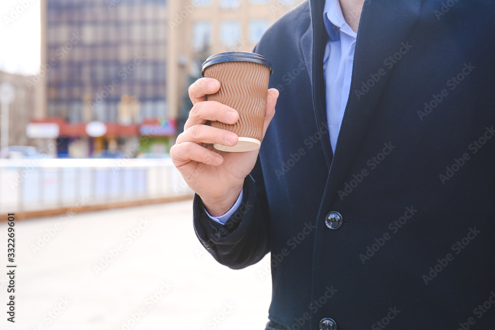 Handsome man with cup of coffee outdoors, closeup