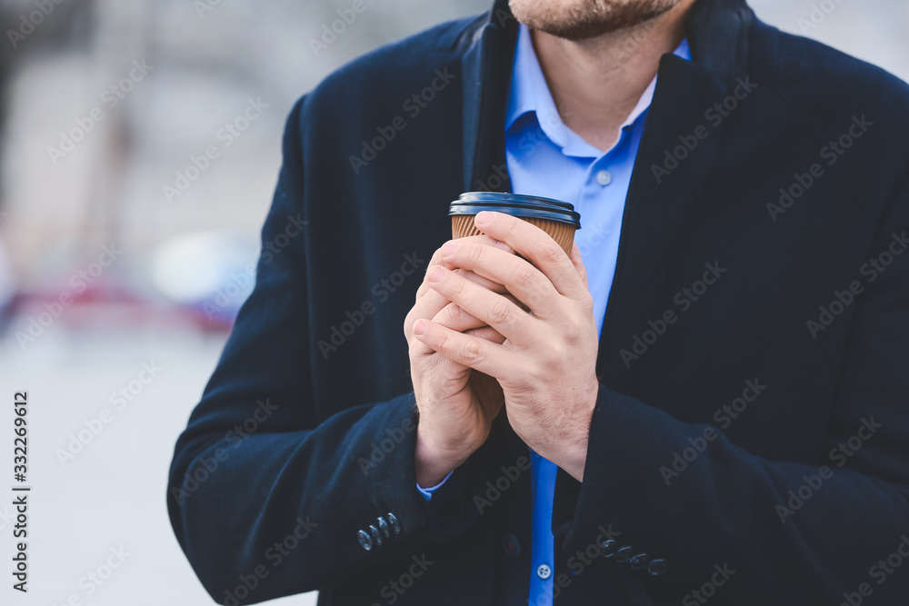 Handsome man with cup of coffee outdoors, closeup