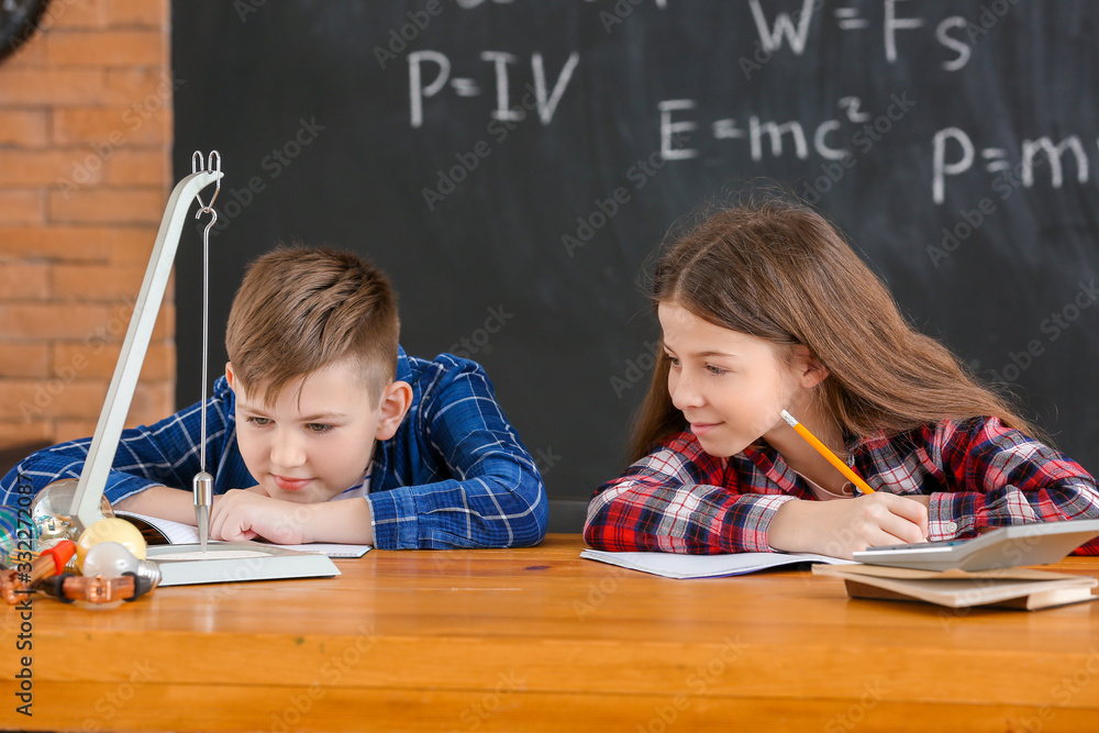 Cute little children at physics lesson in classroom