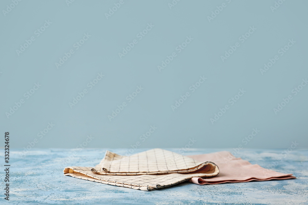 Napkins on table against color background