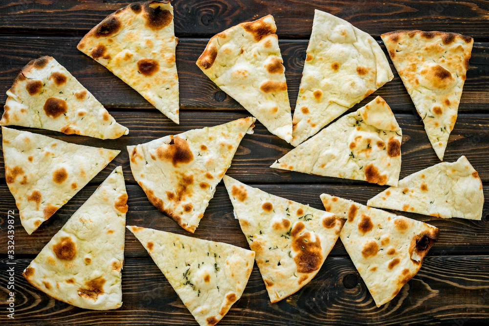 Focaccia pieces background on dark wooden table top-down