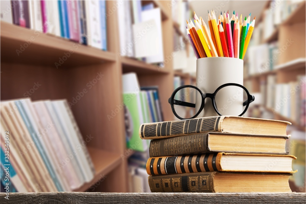 Stack of vintage books and colorful pencils on the desk