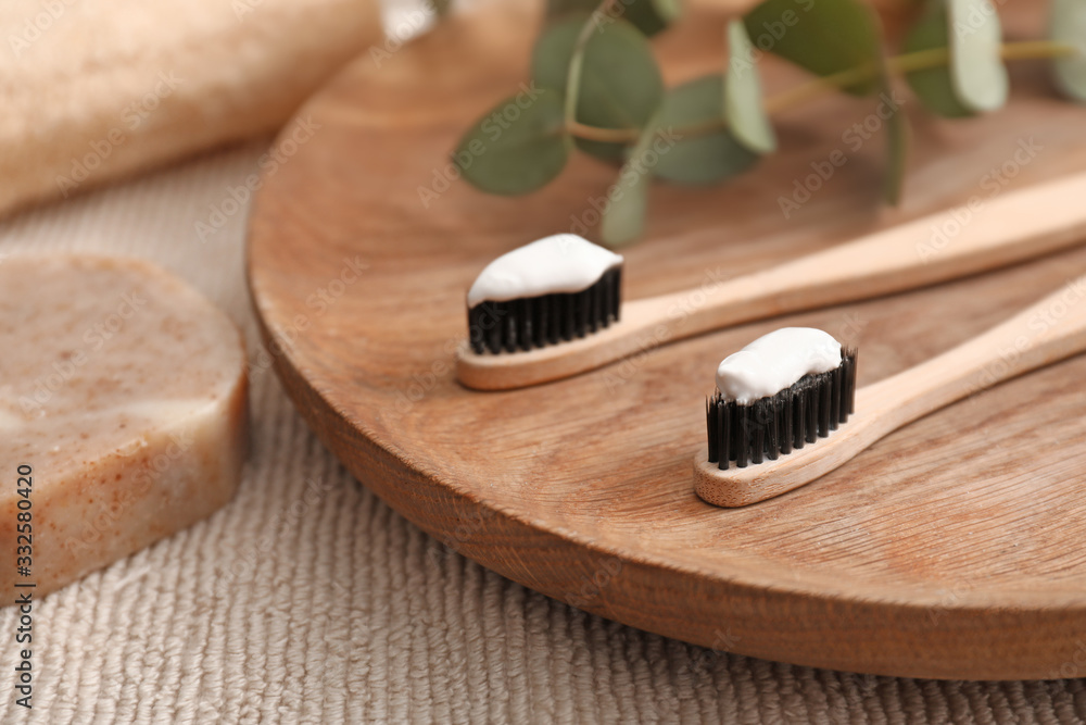 Tooth brushes with paste and soap on table in bathroom