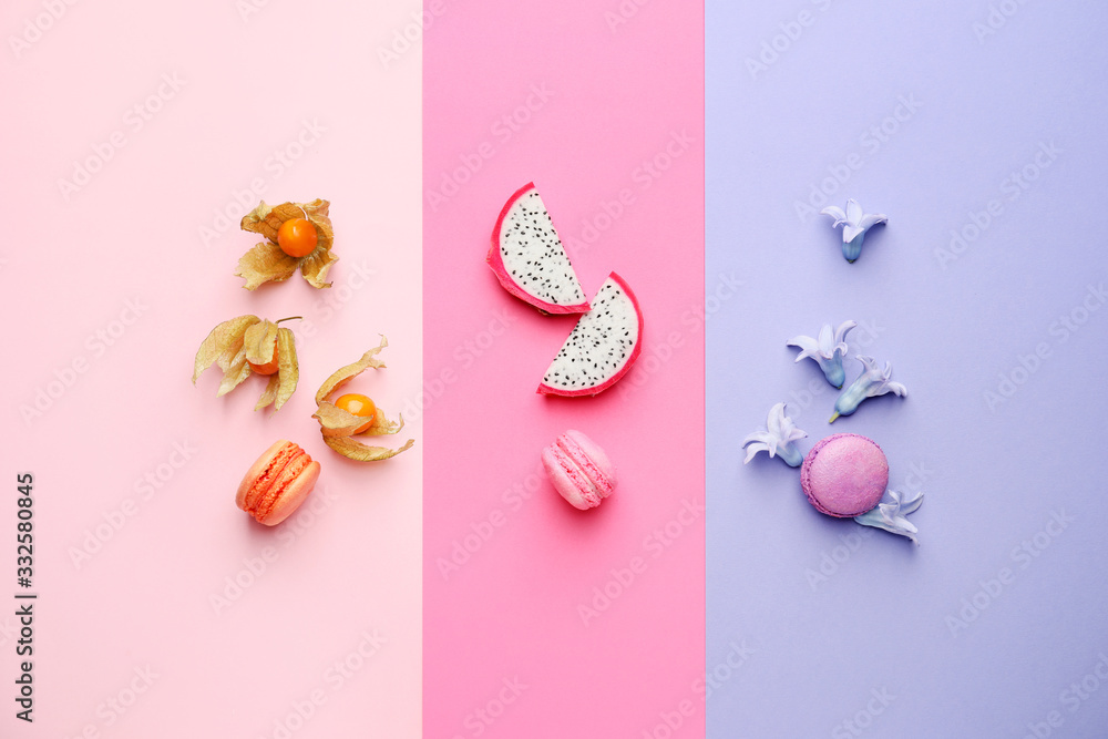 Tasty macarons with fruits on color background