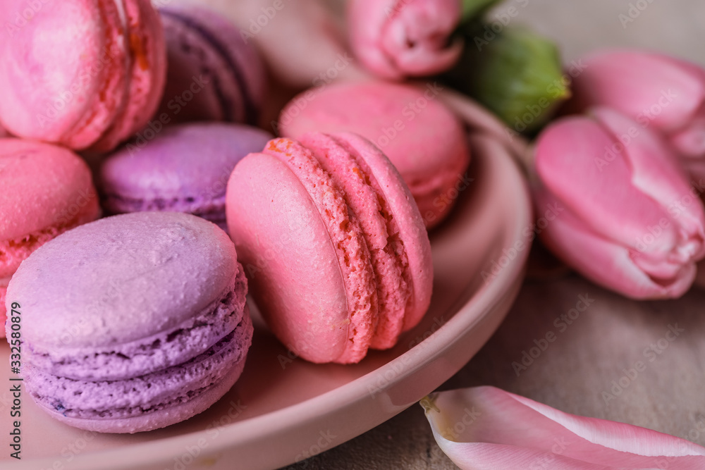 Plate with tasty macarons on table, closeup