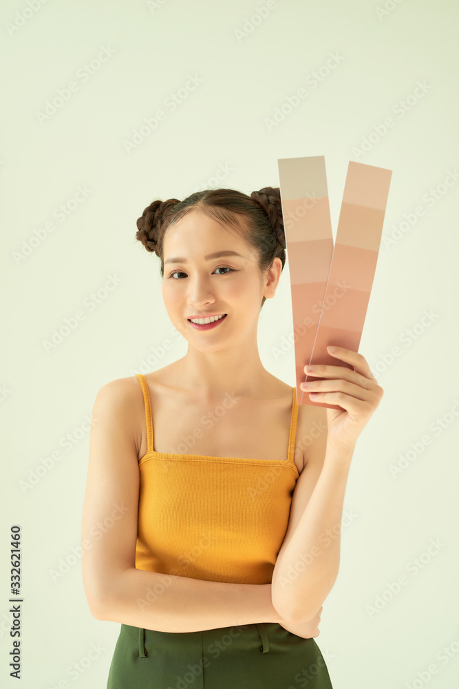 Hand of young happy female showing color palette over light background