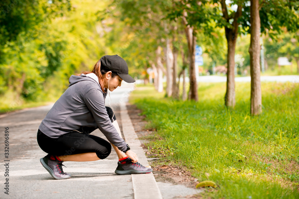 Relax  Asian woman in sport wear shoelace before jogging at park