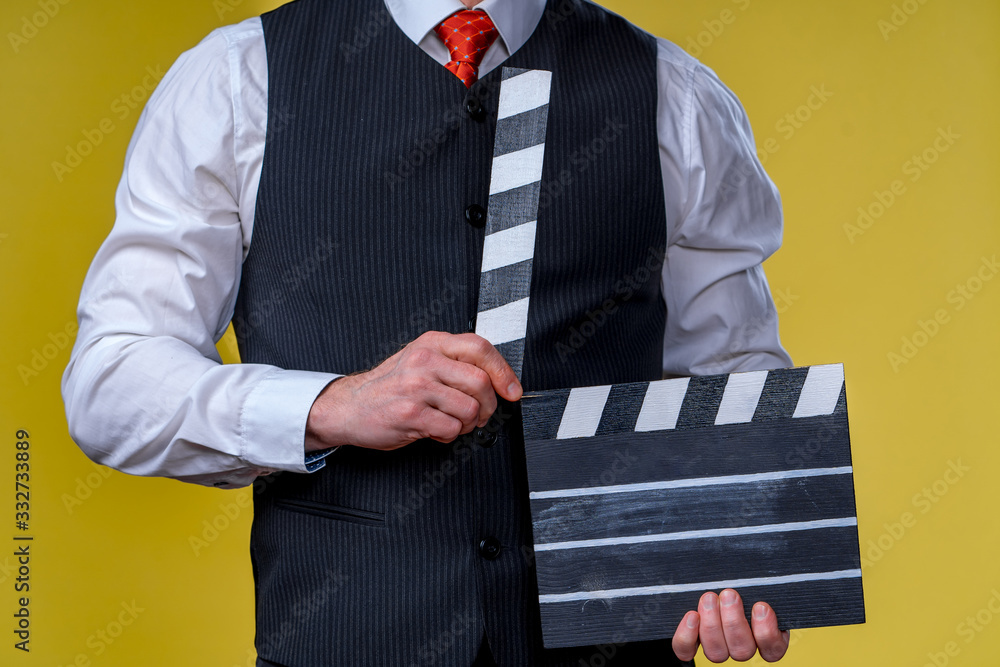 Man with movie flap while filming. Cropped photo. Film production. Human emotions.