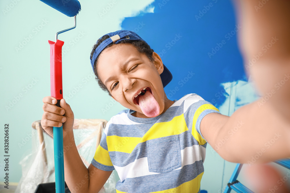 Little African-American painter taking selfie in room