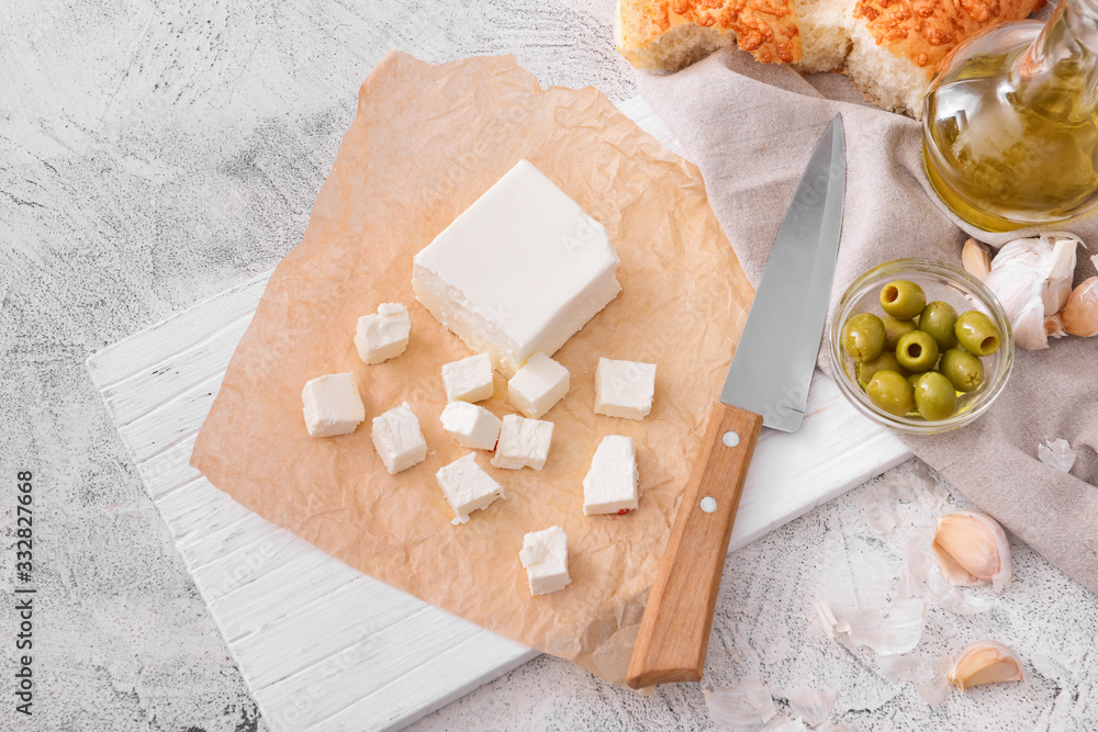 Tasty feta cheese with olives and oil on white background