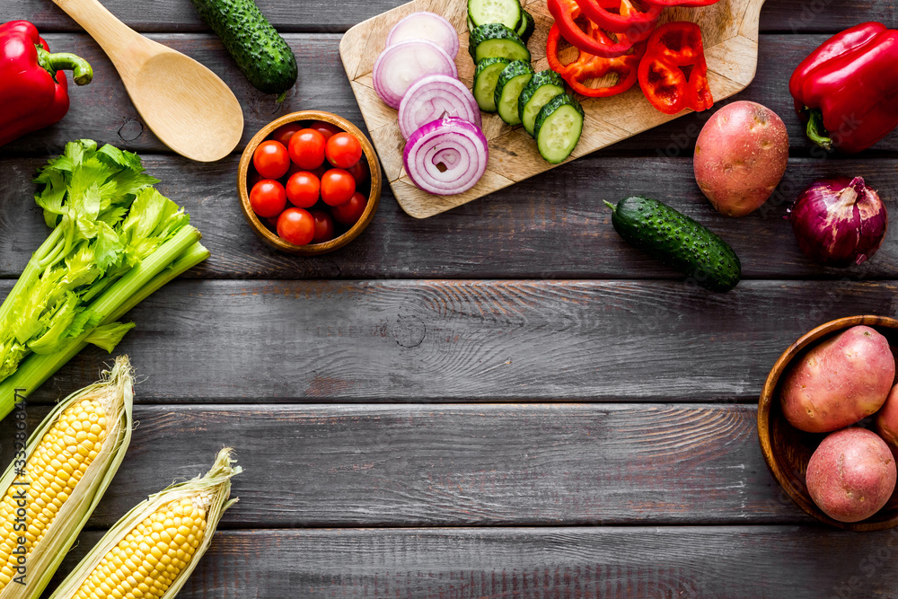 Autumn harvest. Vegetables - potato,cucumber, corn, greenery - frame on dark wooden background top-d