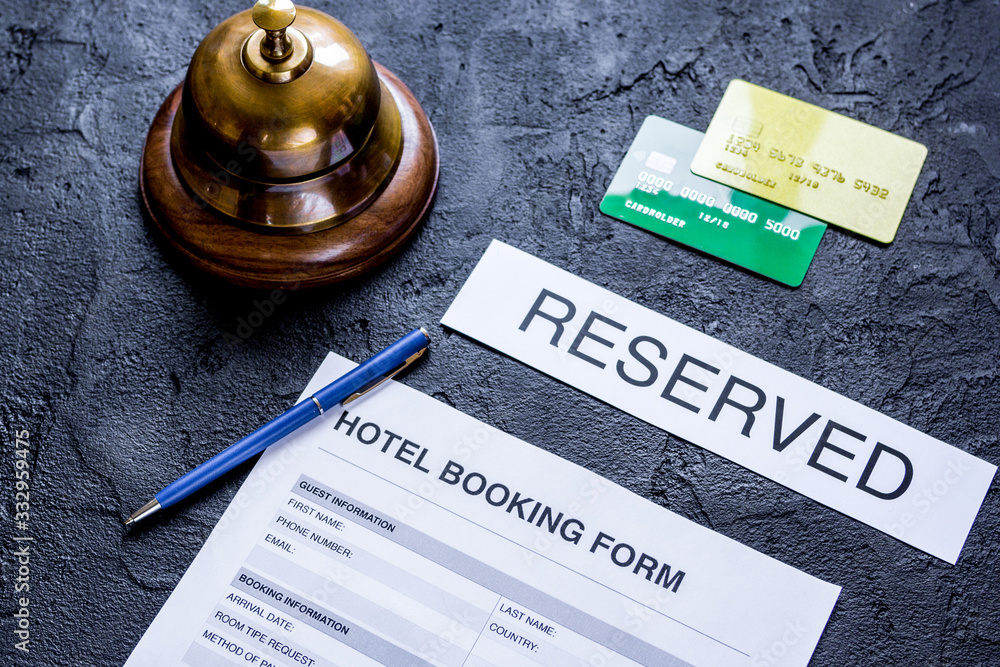 booking hotel room application form and ring dark desk background