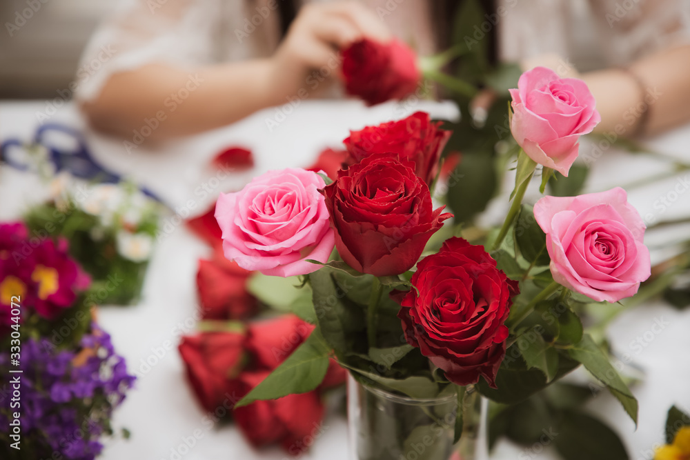 Woman Preparing to trim red and pink roses and beautiful flower arrangements in the home, flower arr