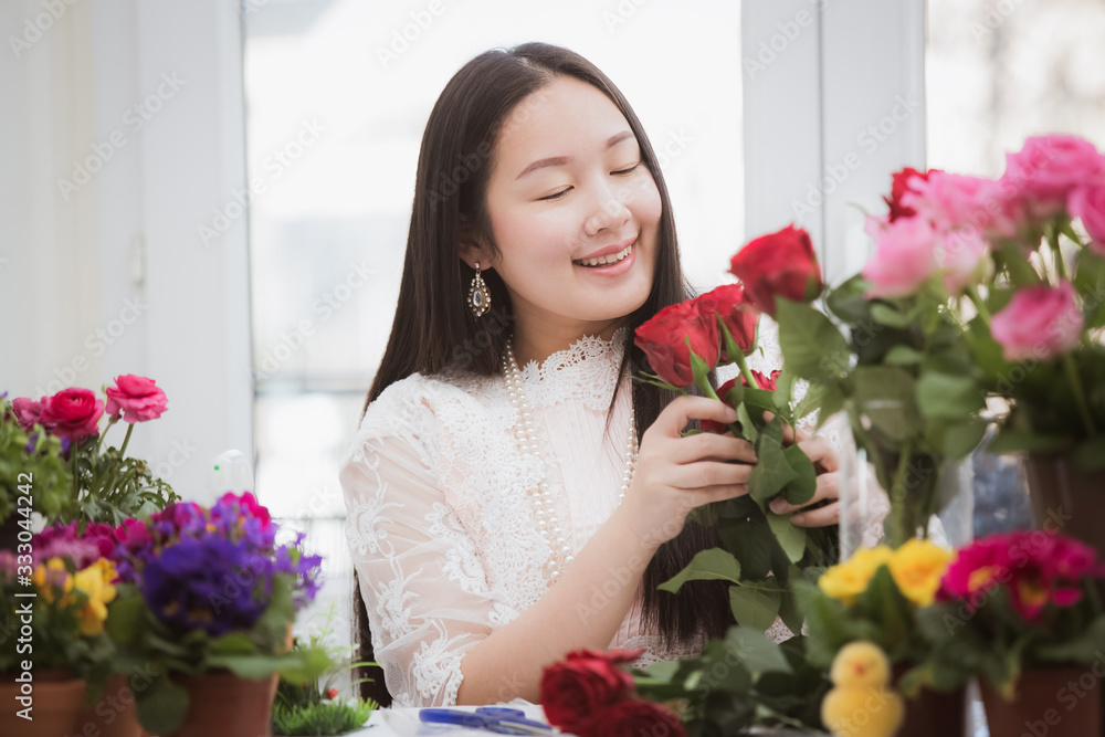 Woman Preparing to trim red and pink roses and beautiful flower arrangements in the home, flower arr