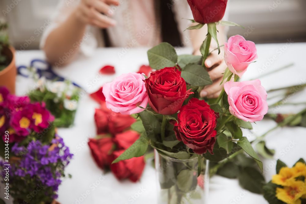 Woman Preparing to trim red and pink roses and beautiful flower arrangements in the home, flower arr