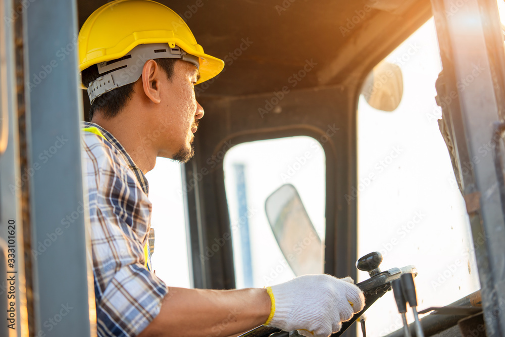 Engineer or architect with white helmet driving Loader Truck at construction site,Engineering Constr