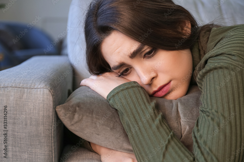 Depressed young woman at home