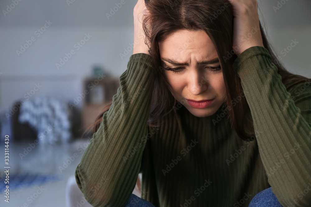 Depressed young woman at home