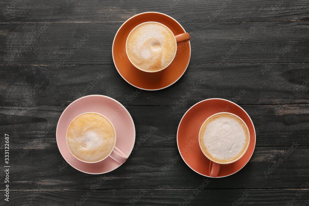 Cups of hot coffee on wooden table