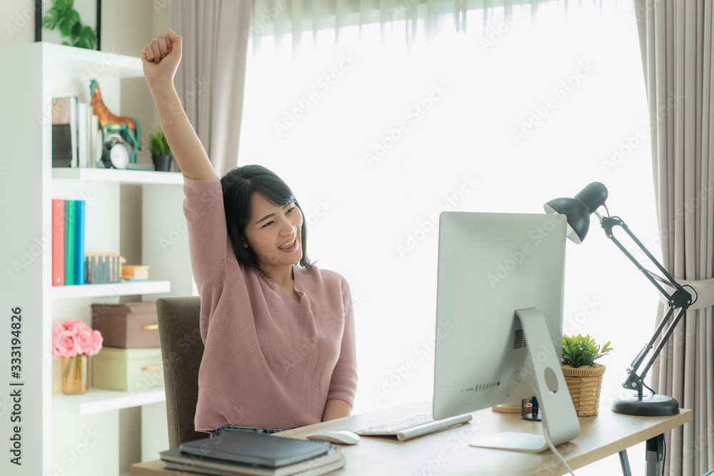 Beautiful Asian business woman work from home and celebrate with computer, success happy pose. E-com