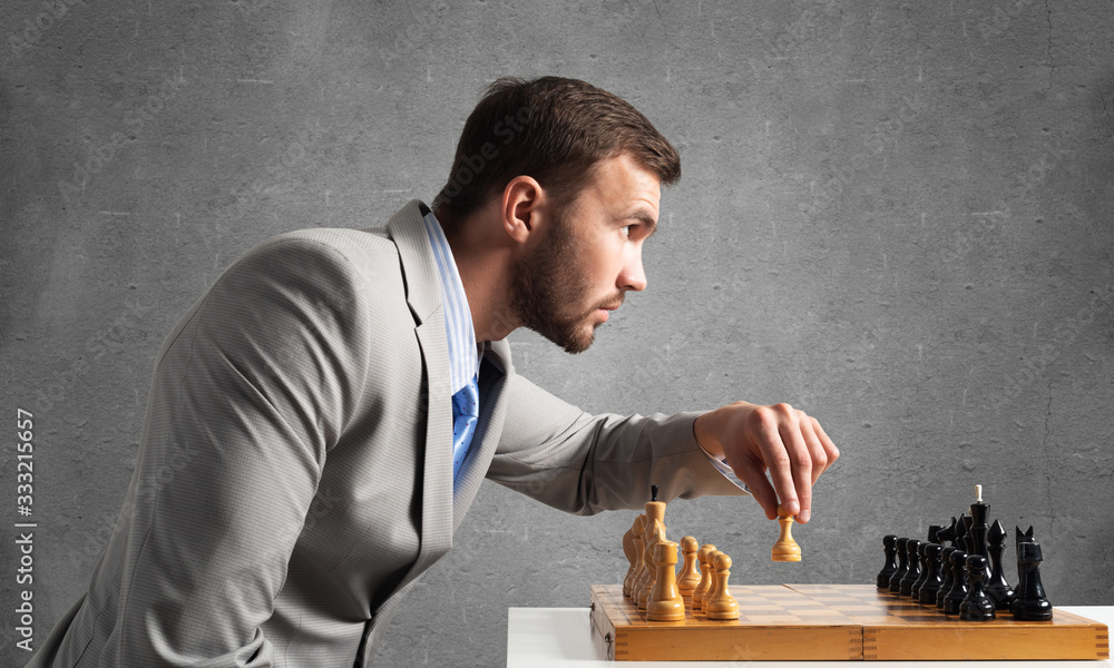 Concentrated businessman playing chess game