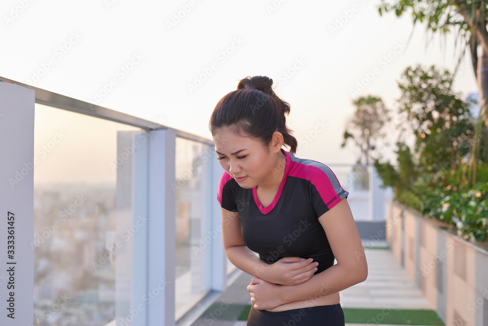 Sport woman stomachache in a park