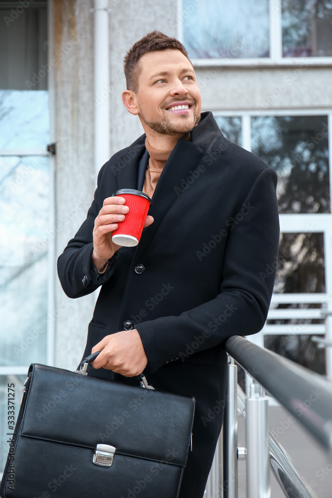 Handsome man with cup of coffee outdoors