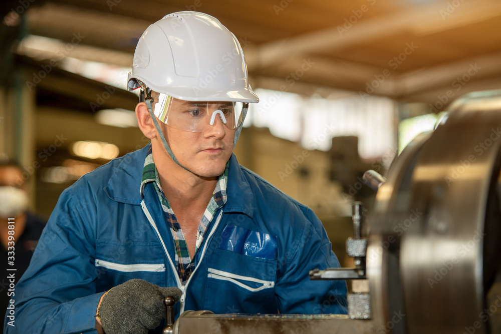 Technician working on lathe spare part machine in iron manufacturing factory,Works in a lathe concep