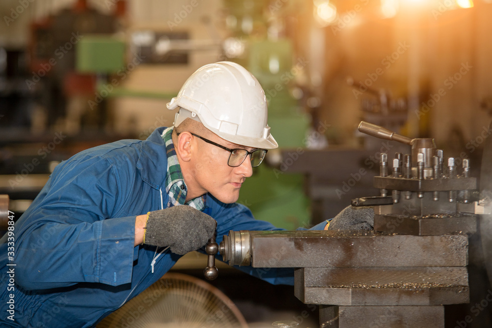 Factory worker,Engineer wearing uniform safety in factory working machine lathe metal.