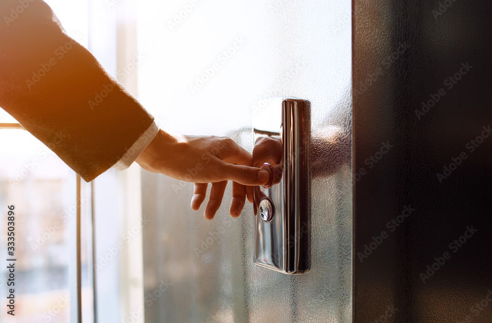 Finger presses the elevator button. Businessman pushing up elevator button. Human hand reaches for t