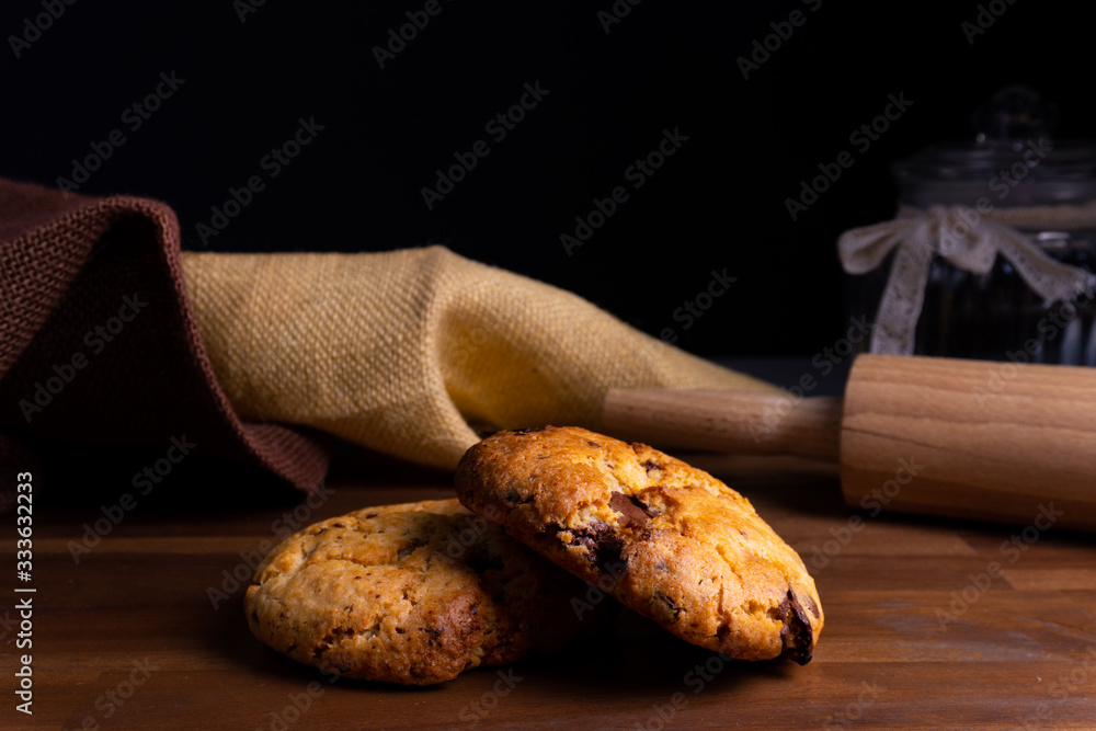 Two delicious cookie cakes with chocolate on a wooden board with copy space