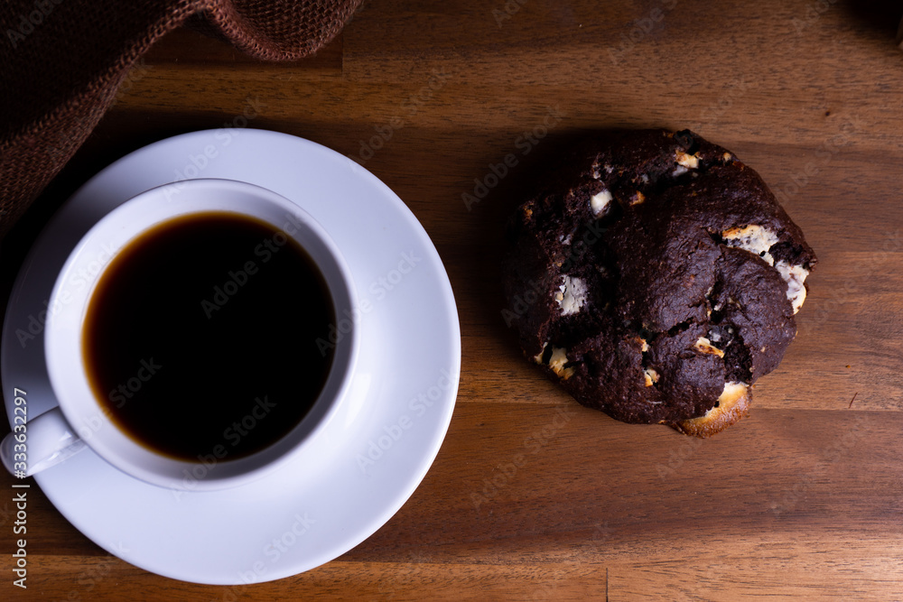 Delicious cookie cakes with chocolate with a cup of coffee on a wooden board with copy space