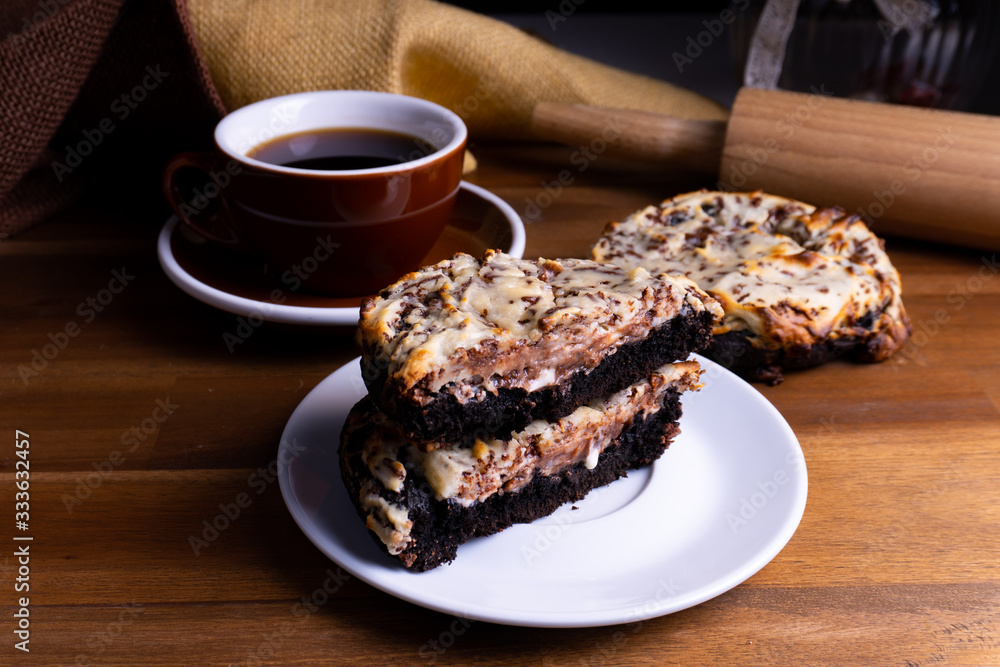 Delicious cookie cakes with chocolate and cheesecake with a cup of coffee on a wooden board with cop